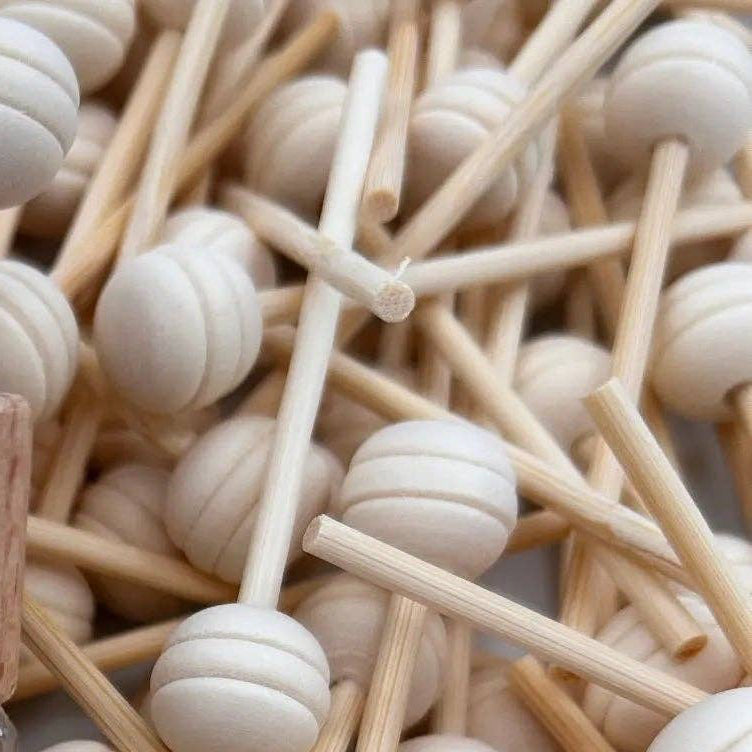Perfume bottle labeled 'Beach House' surrounded by wooden sticks and beads