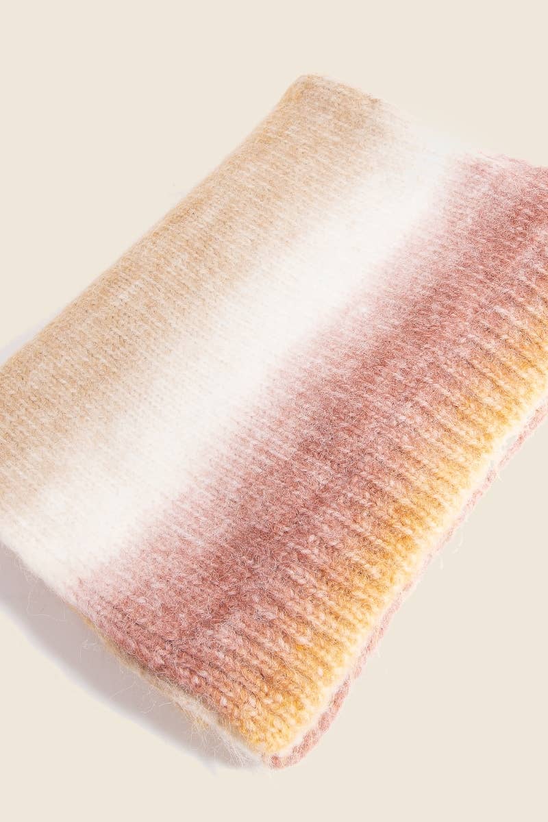 Gradient pillow with pink, orange, and white colors on a beige background