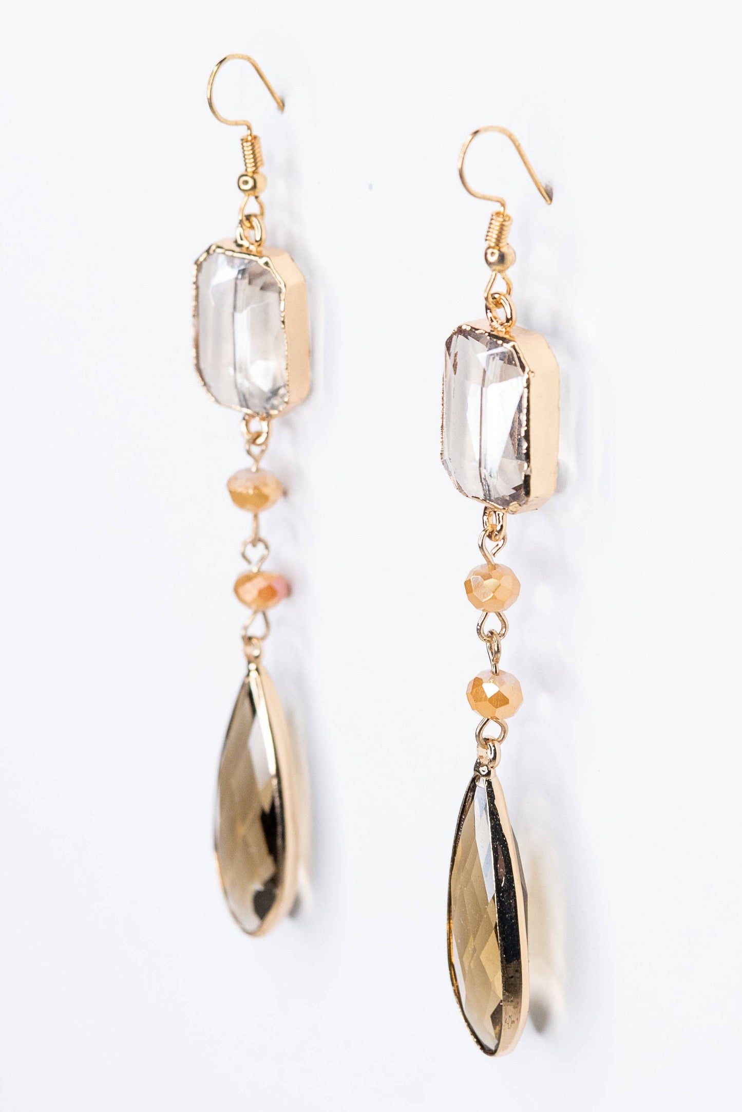 Pair of earrings with clear and gold beads on a white background
