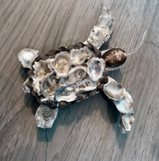Decorative turtle ornament made of shells on a wooden surface