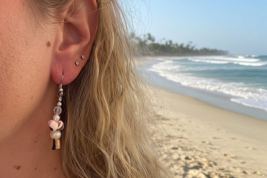 Close-up of an ear with a pearl earring and beach background