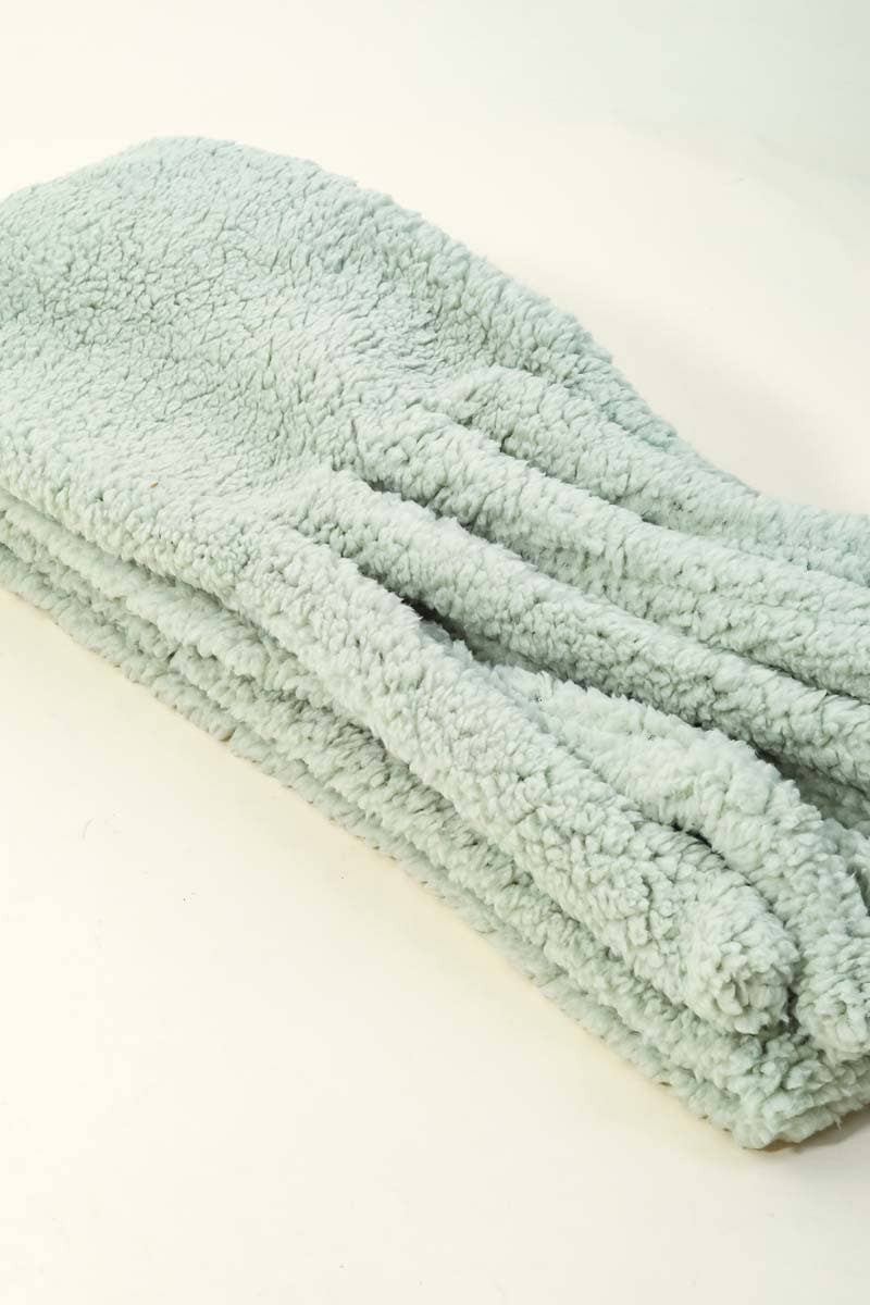 Folded light green towel on a white background