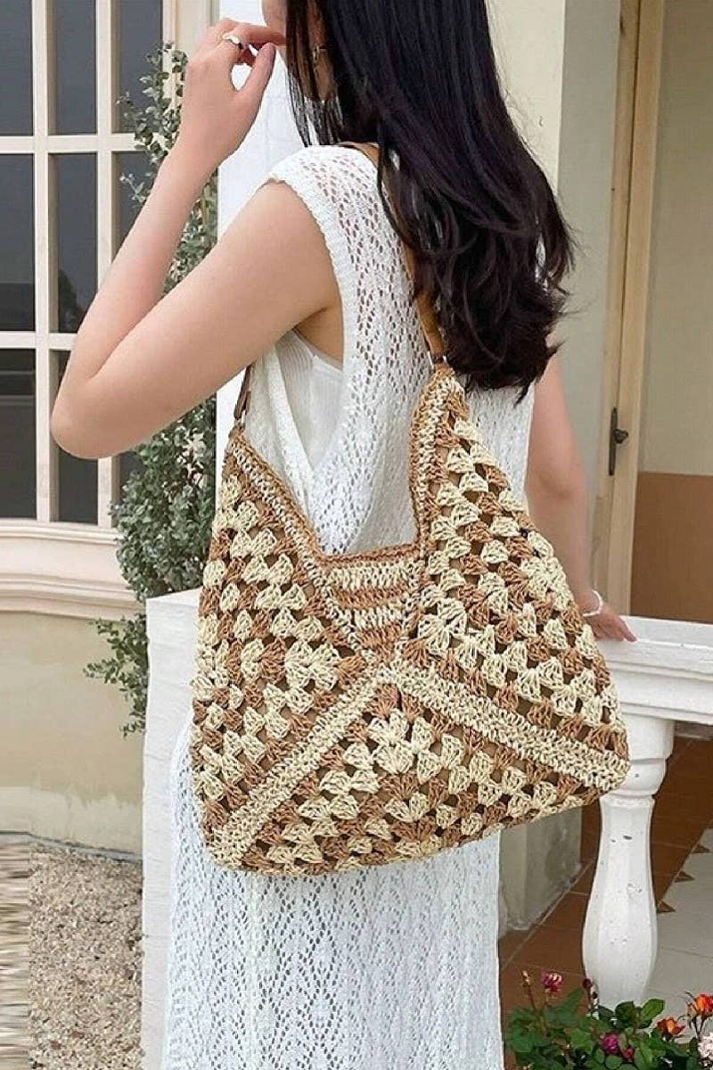Woman carrying a large, patterned crochet bag outdoors.