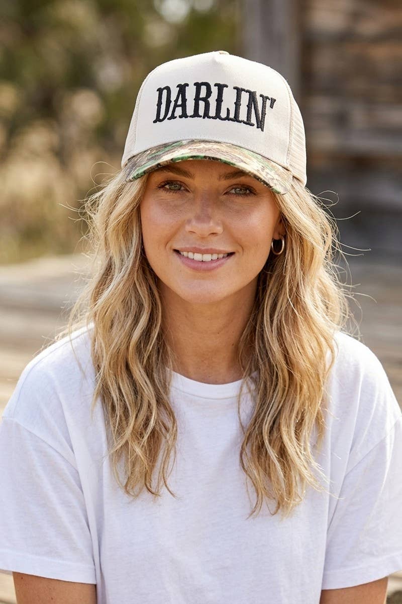 Woman wearing a cap with 'Darlin' text outdoors