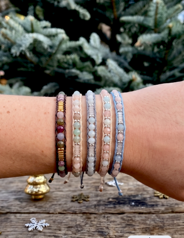 Beaded braid bracelets with  pastel and earthy tones including pink, blue-gray, light green, gold, and dark brown by Lotus & Luna.