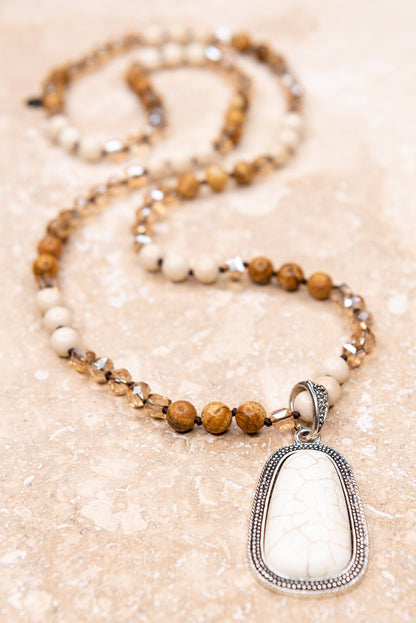 Necklace with a pendant on a textured beige surface