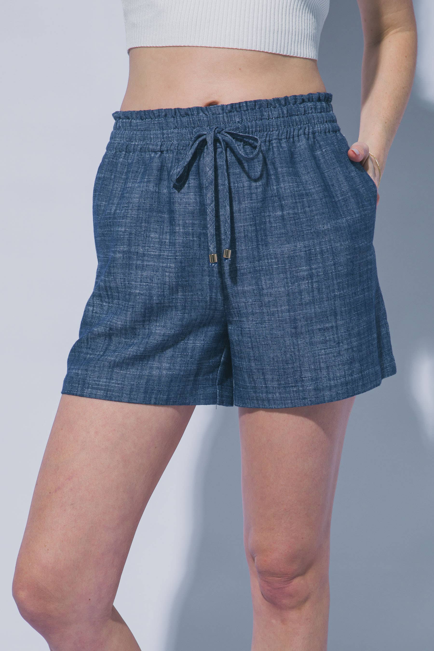 Blue shorts with a drawstring on a plain background