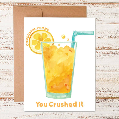 Congratulations card with an orange drink on it on wood background