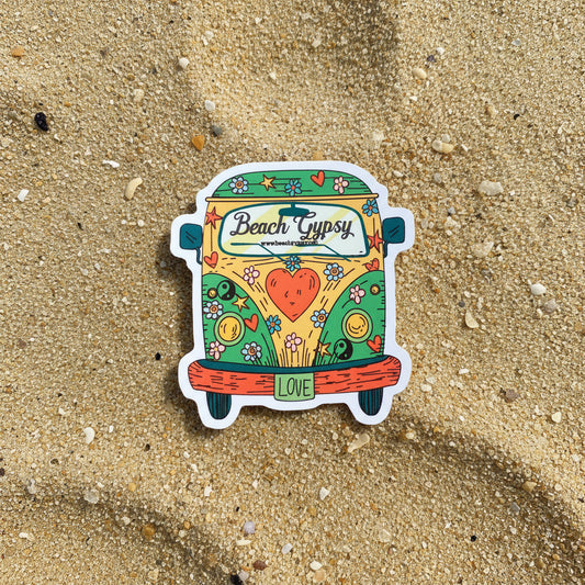 Colorful sticker of a van with 'Beach Gypsy' branding on a sand background