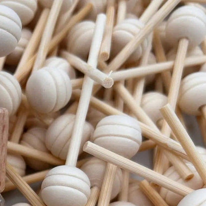 Perfume bottle labeled 'Beach House' surrounded by wooden sticks and beads