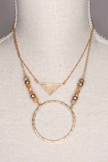 Gold necklace with geometric pendant on a mannequin bust