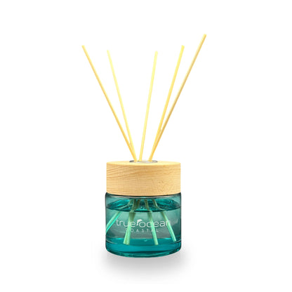 Reed diffuser with wooden cap and blue container on a white background