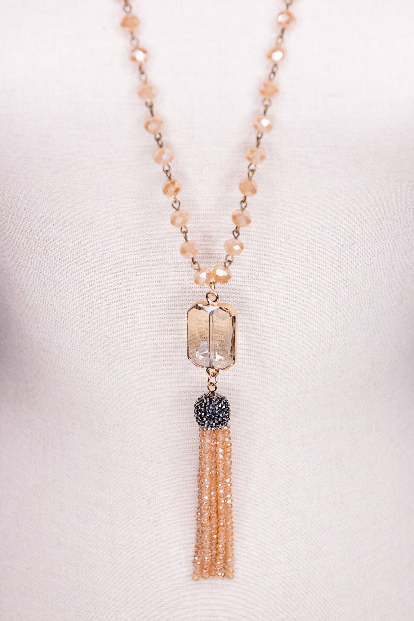 Necklace with beads and tassel on a light background