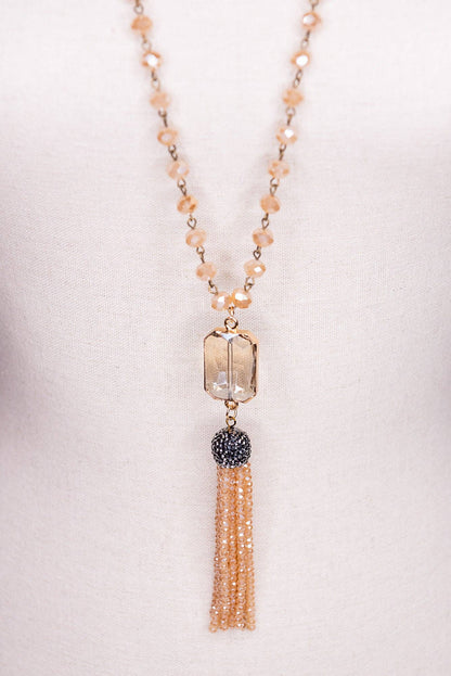 Necklace with beads and tassel on a light background