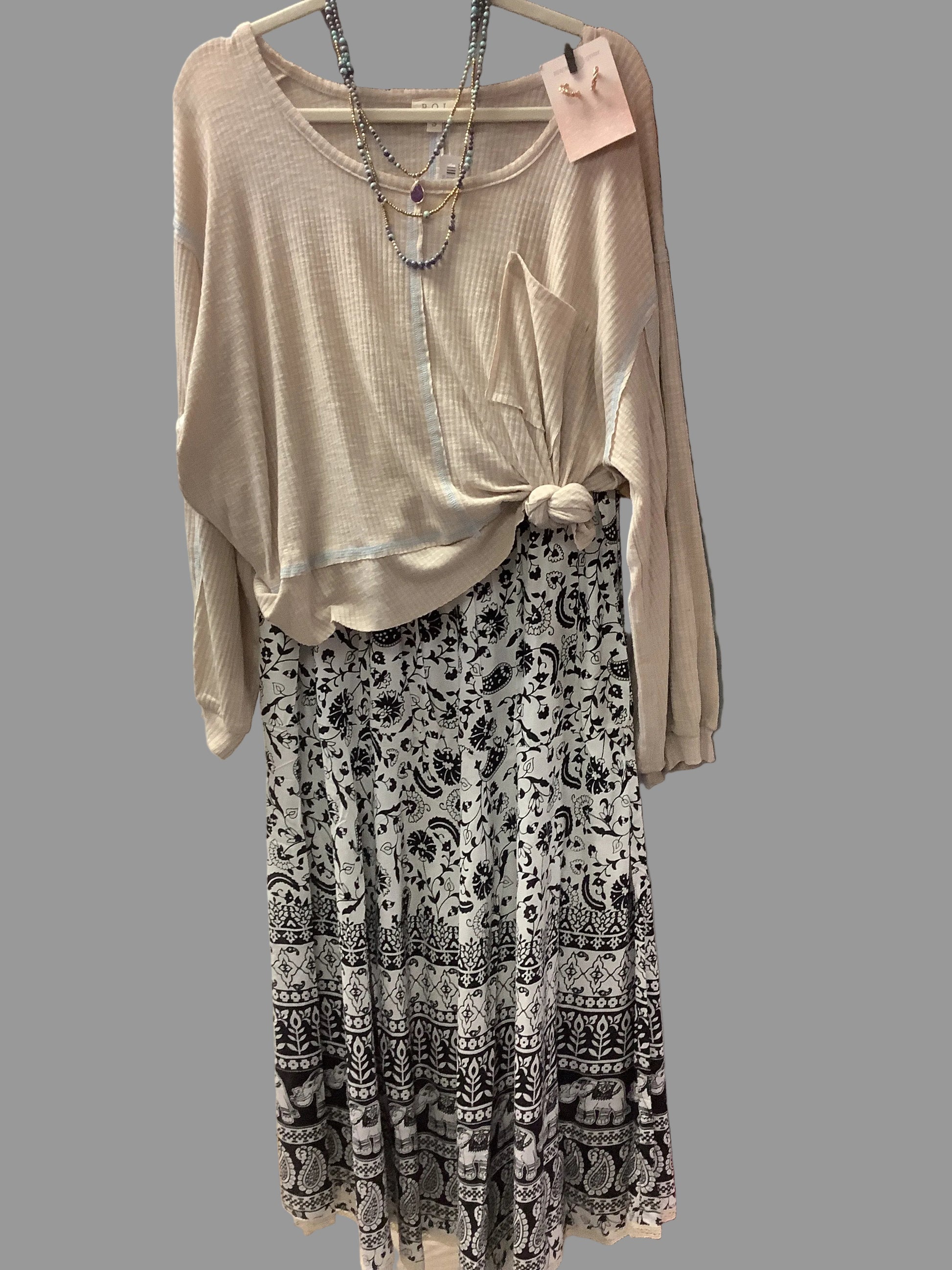Black and white floral and elephant printed skirt. Paired with beige top with necklace and earrings.