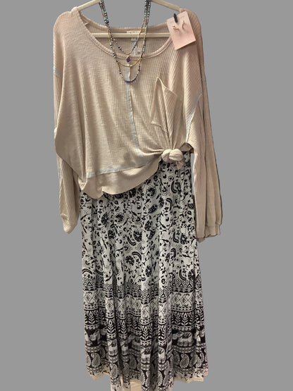 Black and white floral and elephant printed skirt. Paired with beige top with necklace and earrings.
