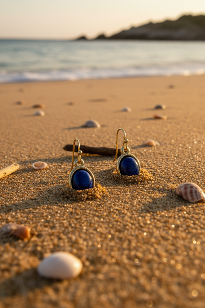 Blue dangle earrings in sand beach