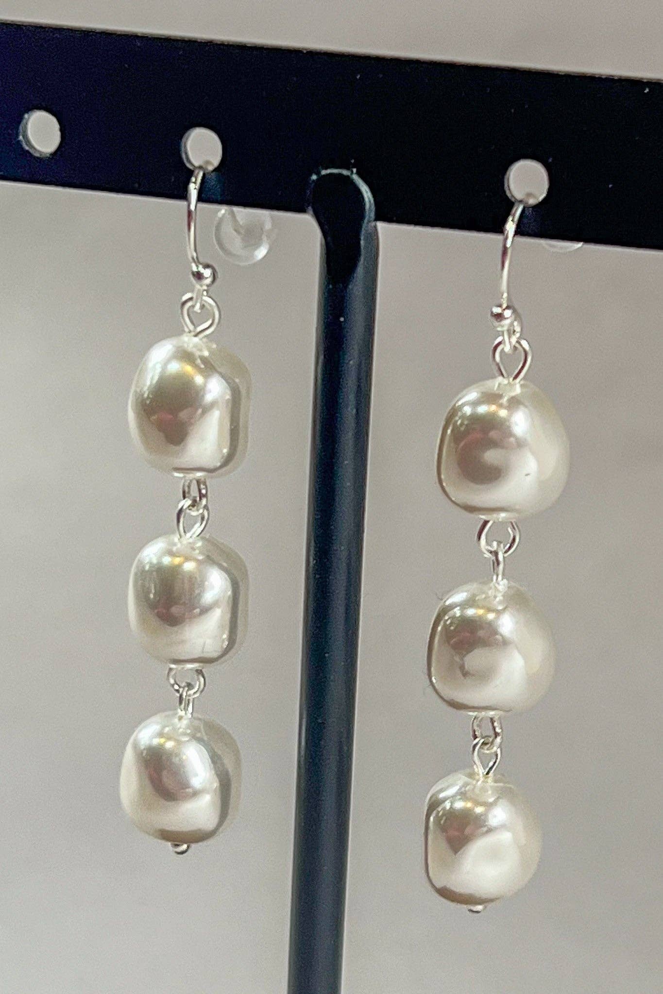 3 pearl drop earrings on a stand