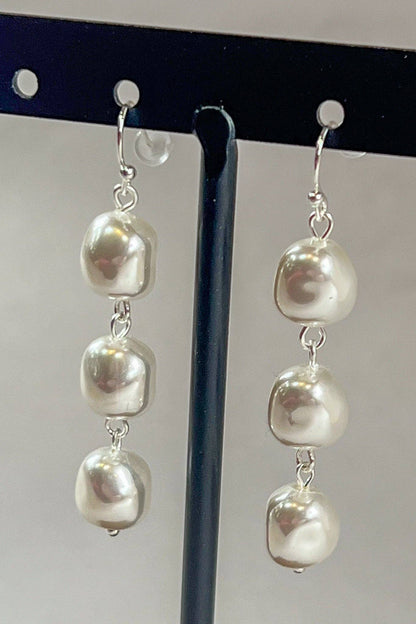 3 pearl drop earrings on a stand