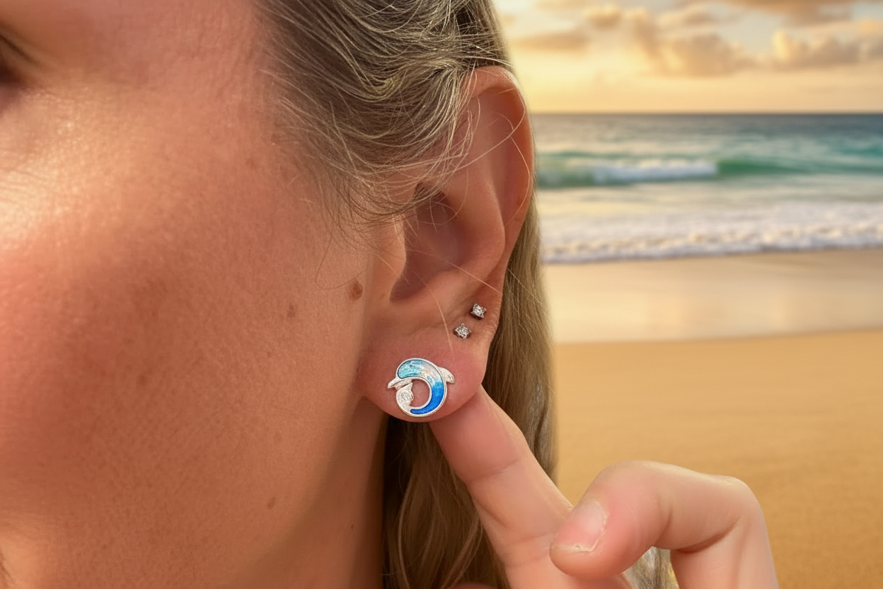 Close-up of an ear with a blue and silver dolphin earring.