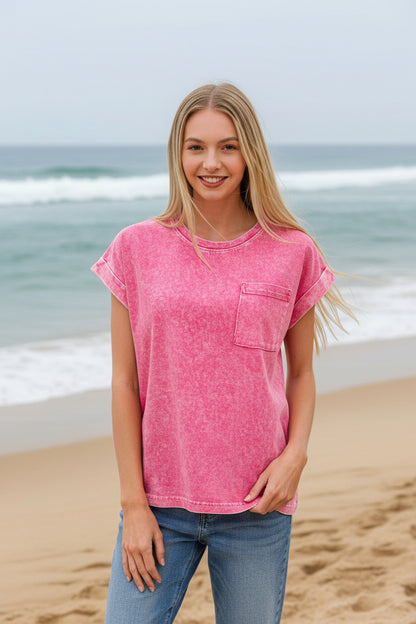 Woman wearing a hot pink t-shirt with a pocket on a beach background