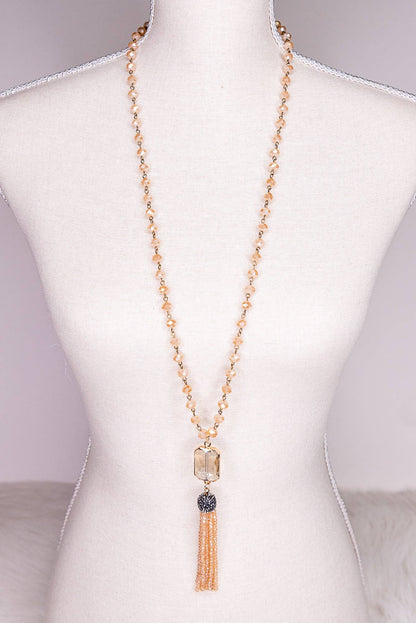 Necklace with tassel on a mannequin bust against a neutral background