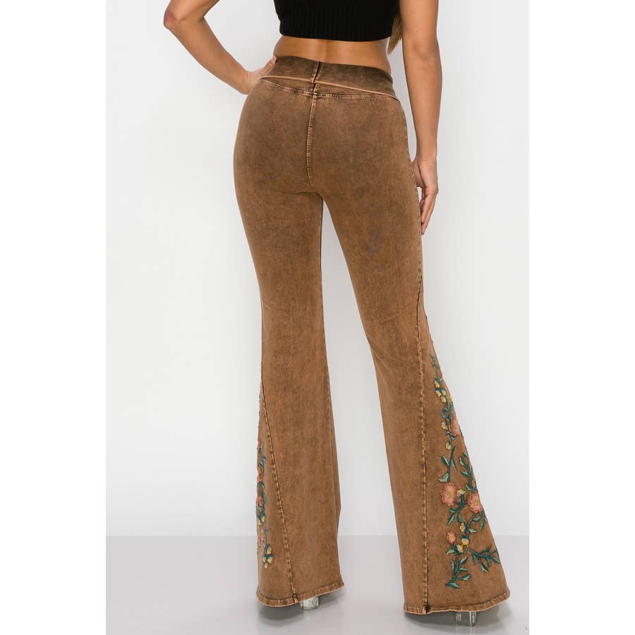 Brown flared jeans with floral embroidery on a white background