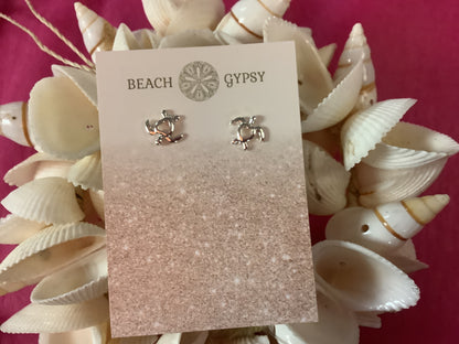 Silver earrings on a 'Beach Gypsy' branded card surrounded by seashells.