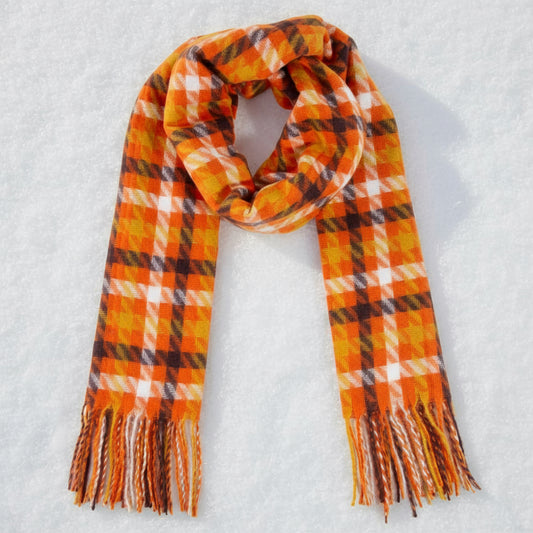 Plaid scarf with orange, brown, and white pattern on a beige background