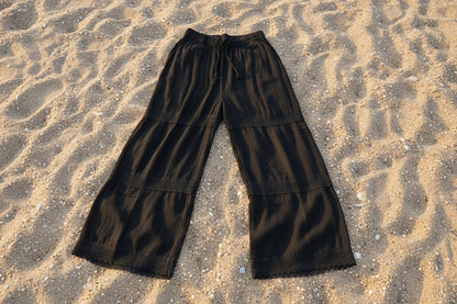 Black wide-leg pants on a textured surface