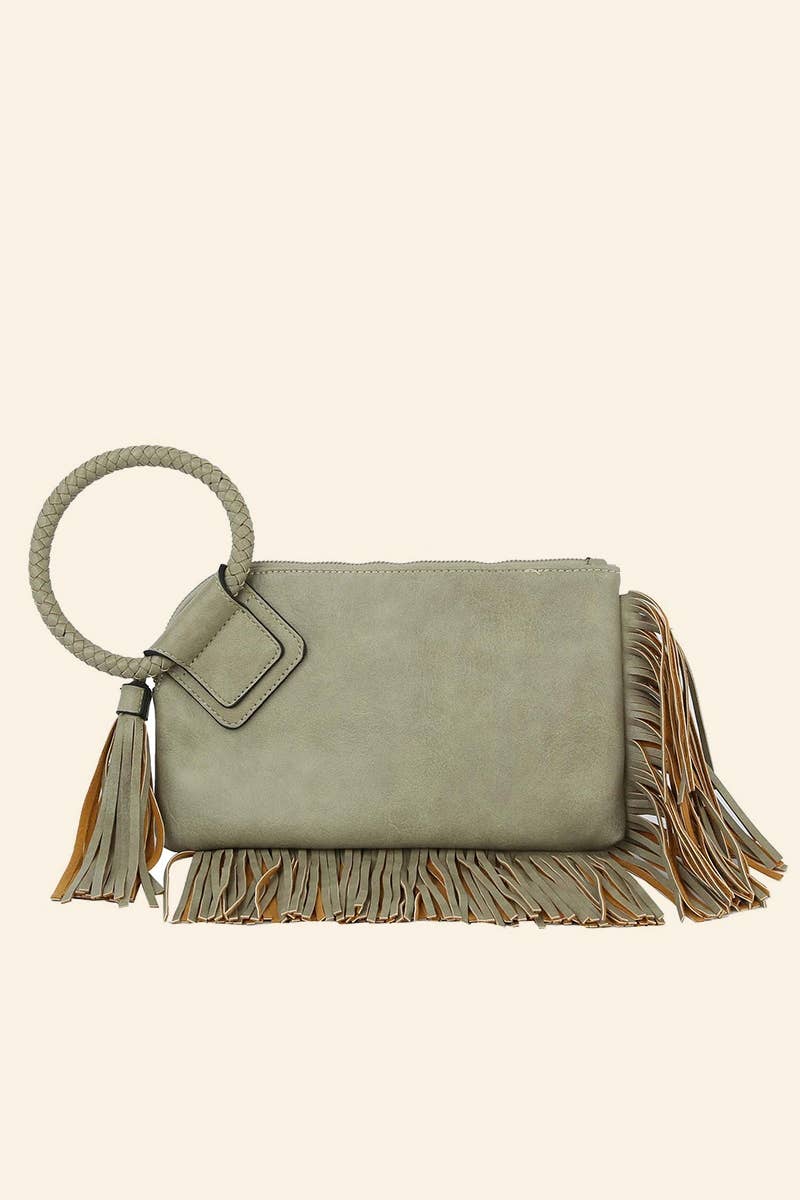 Green handbag with fringe details on a beige background