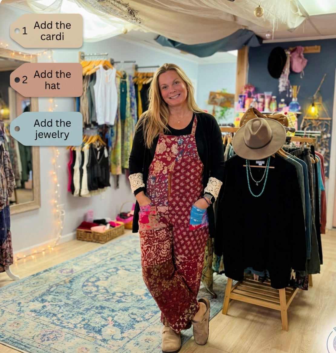 Woman is wearing a patchwork jumpsuit  in a store with clothing and accessories around her