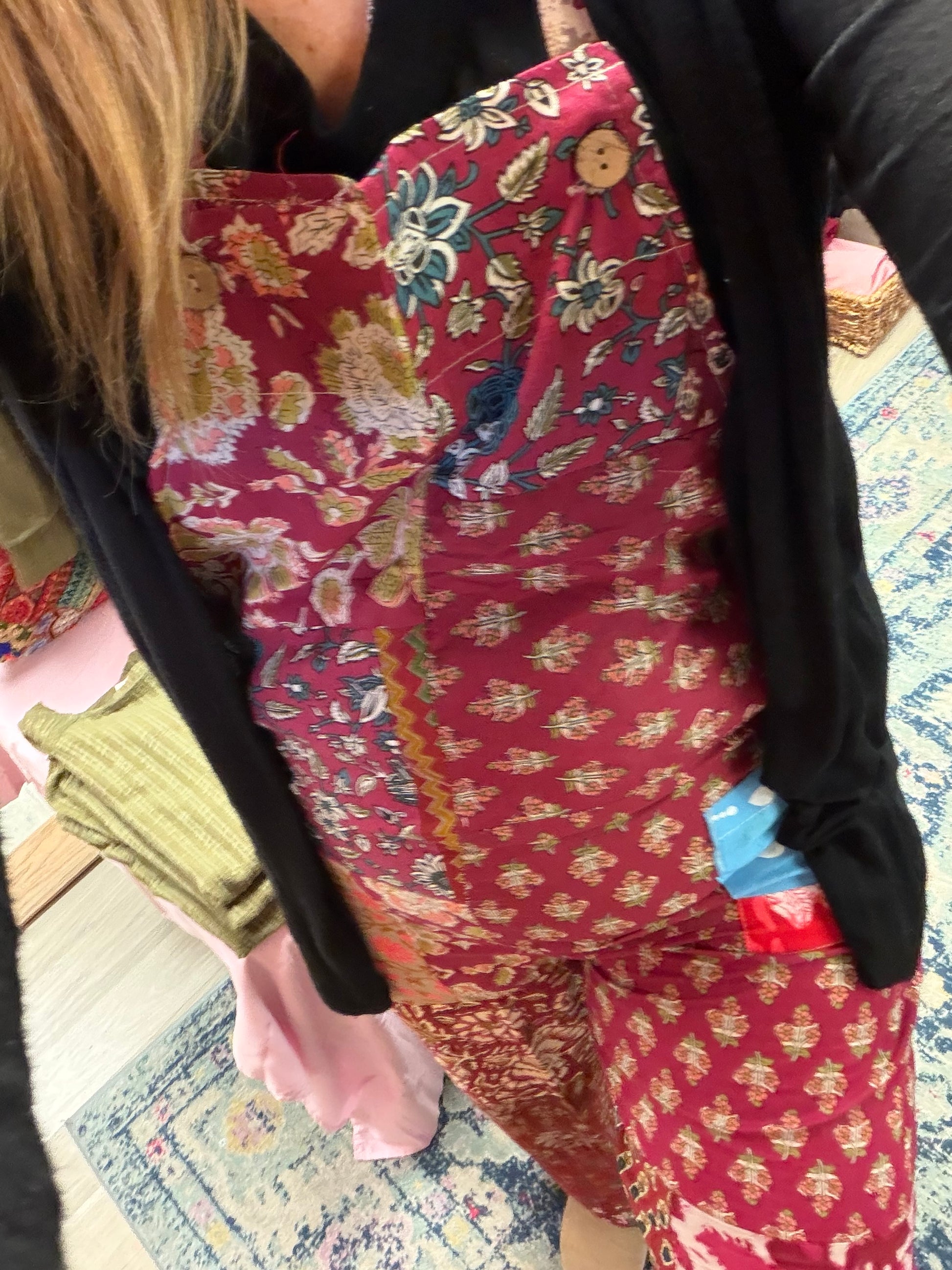 Person wearing a red floral patterned jumpsuit with a black jacket.