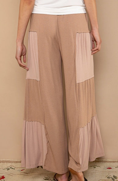 back view woman wearing chocolate colored patch  flowy pantsf 