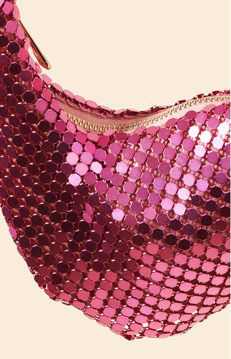 Close-up of a pink sequin handbag on a beige background