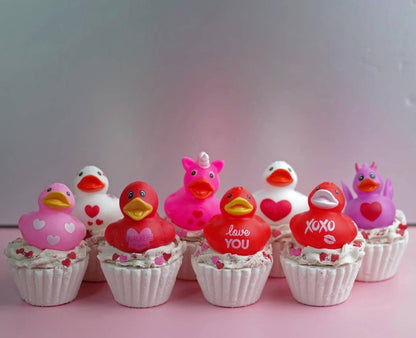 Cupcakes with rubber duckies on top against a pink background