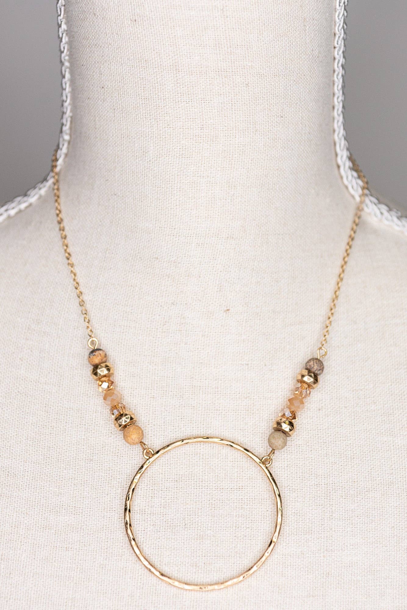 Necklace with a gold hoop pendant on a mannequin bust.