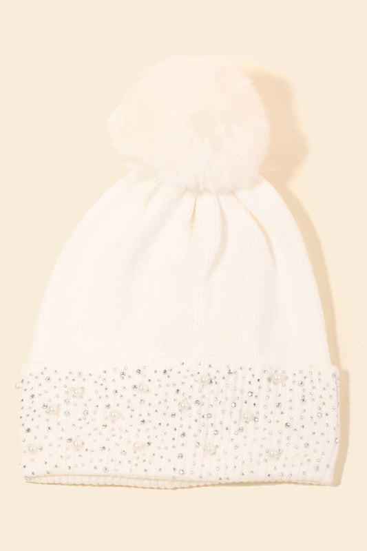 White hat with jewels on a beige background