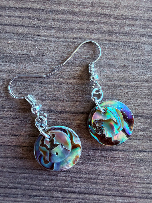 Abalone shell earrings on a wooden surface