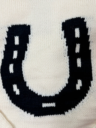 Closeup of black horseshoe or white knit sweater 