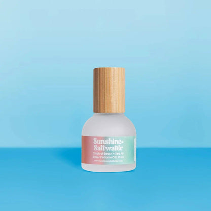 Sunshine & Saltwater fragrance bottle with wooden cap on a blue background