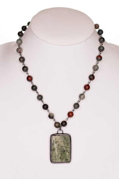 Necklace with a pendant on a mannequin against a white background
