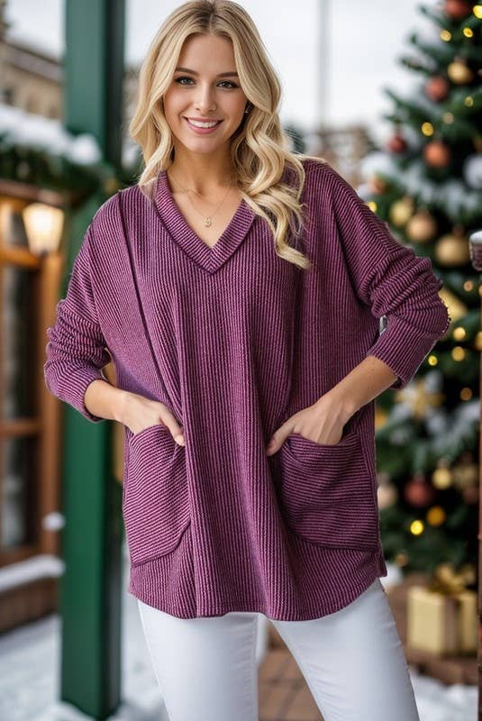 Woman wearing a purple sweater with a Christmas tree in the background