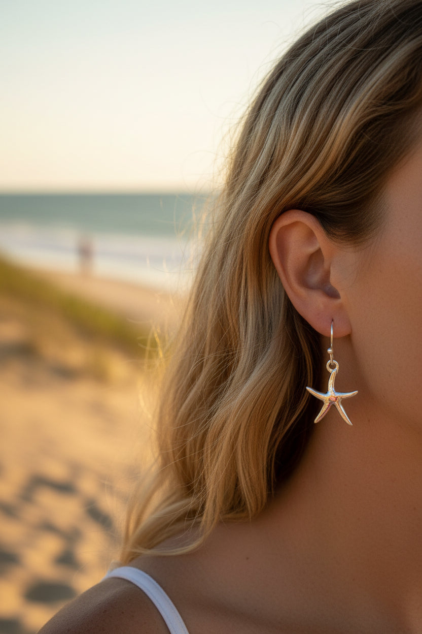 Starfish-shaped earrings on a woman in a beach background 