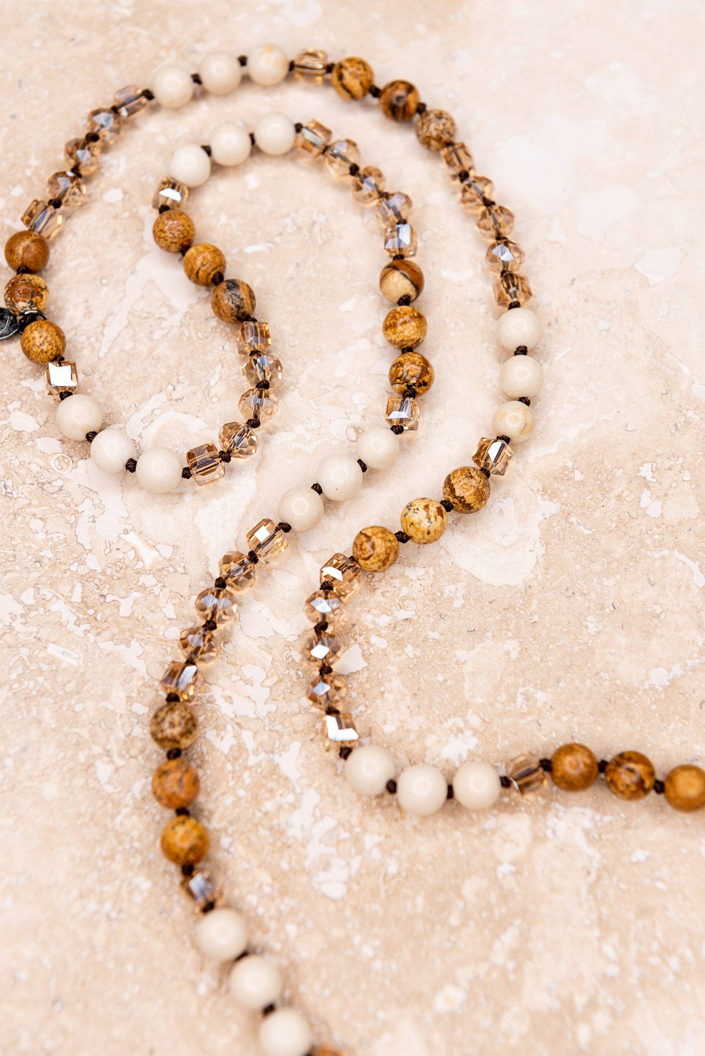Brown & White Beaded necklace on tan background