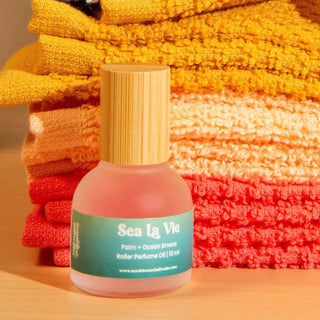 Sea La Vie roller perfume oil bottle with colorful towels in the background