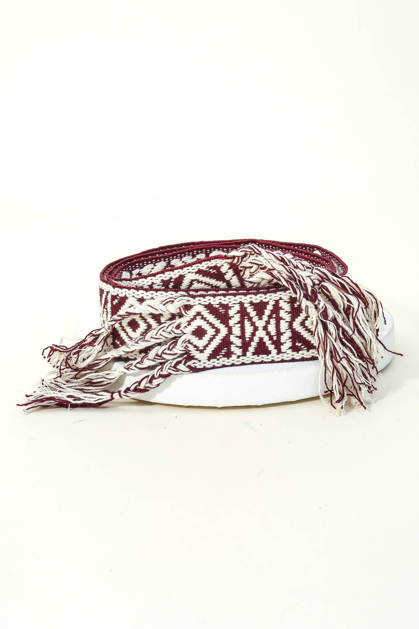 Hand-woven headband with brown and white pattern on a white background