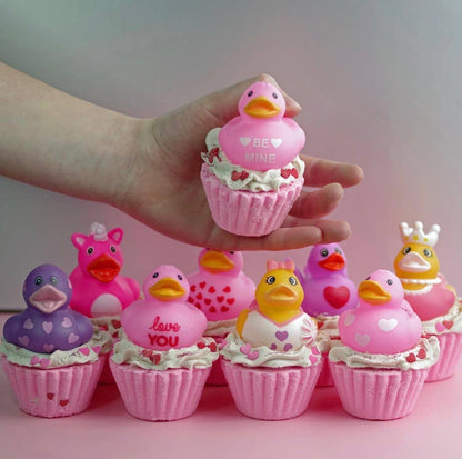 Pink duck-shaped cupcakes with decorative elements on a pink surface