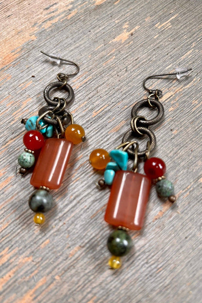 Pair of earrings with colorful beads on a wooden surface