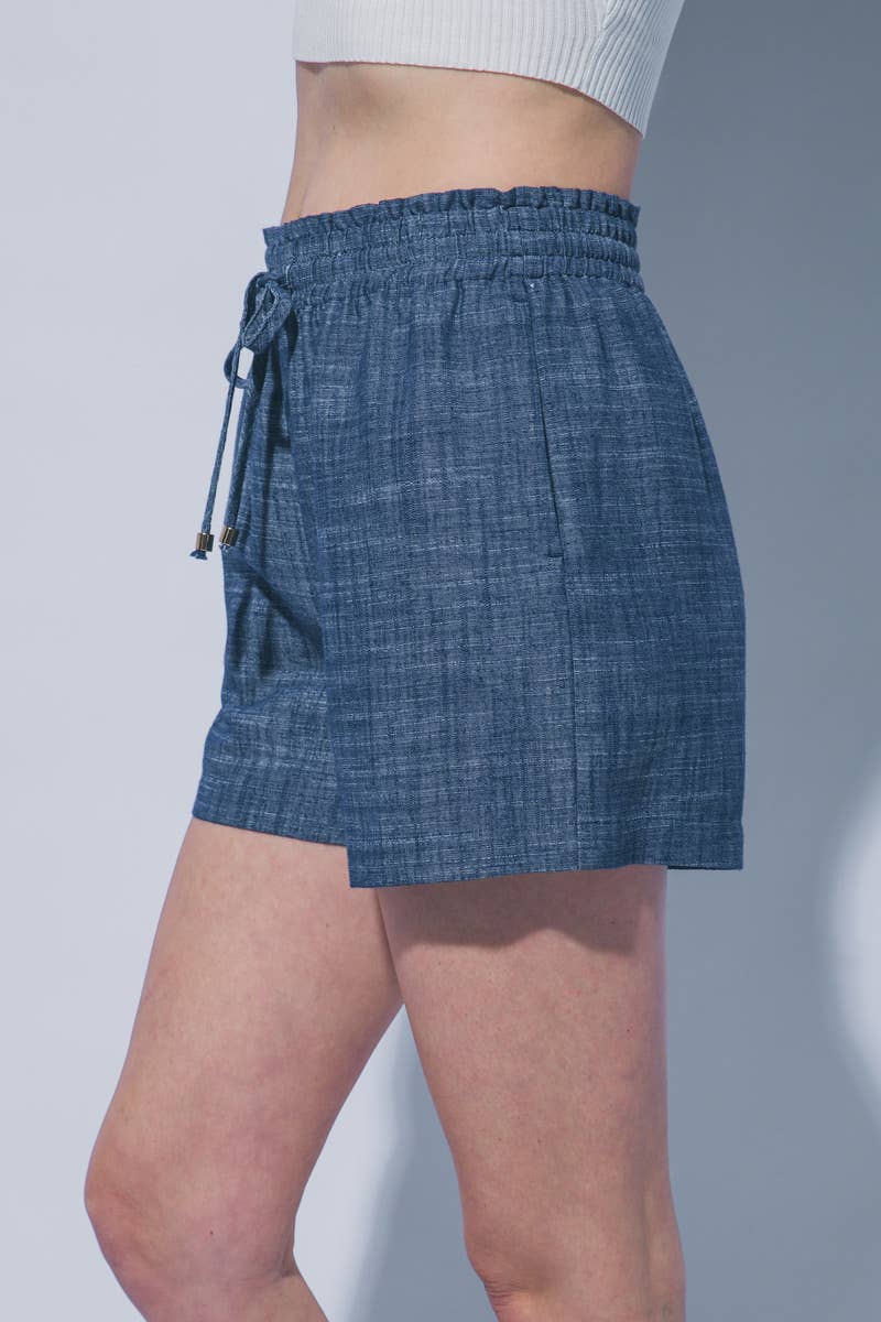 Blue denim skirt worn by a person on a plain background